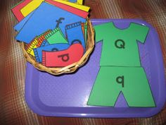 a purple tray with clothes on it and a basket filled with paper cut outs in the middle