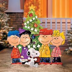 a christmas card with the image of charlie brown and his family in front of a tree