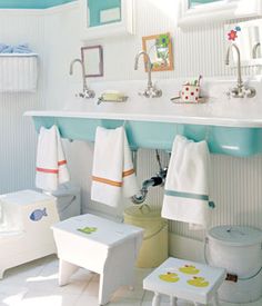 a bathroom with blue and white walls, two sinks and towels hanging on the wall