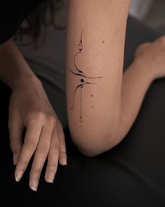 a woman's arm with a small tattoo on the left side of her body