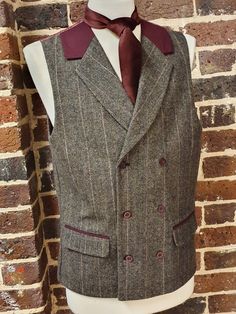 A uniquely designed, mens double breasted brown and deep red tweed waistcoat with a mock-suede collar.  Item is beautifully designed with Burgundy suede edging on the pockets and collar, and can be closed via three buttons on the front of the waistcoat.  This waistcoat as you can see has a unique back with a paisley design also in a deep red burgundy colour. The waistcoat can be adjusted with a button system adjustment also shown. This is ideal for a wedding or casual wear, great with a suit or a pair of jeans. Please see our online etsy shop to view our range of Tweed products for that perfect winter look. Fitted Single-breasted Tweed Vest, Brown Double-breasted Tweed Jacket For Tailoring, Fitted Brown Double-breasted Tweed Jacket, Fitted Double-breasted Brown Tweed Jacket, Brown Fitted Double-breasted Tweed Jacket, Fitted Tweed Vintage Vest, Fitted Vintage Tweed Vest, Vintage Fitted Tweed Vest, Winter Brown Tweed Vest