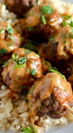 meatballs with gravy on top of white rice and garnished with cilantro