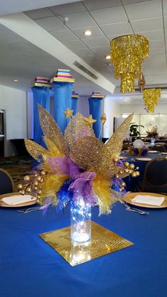 a vase filled with flowers sitting on top of a blue table cloth covered dining room