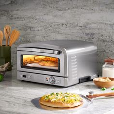 a toaster oven sitting on top of a counter next to a plate with food