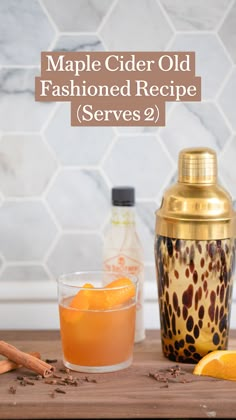 an orange and cinnamon drink sitting on top of a wooden table next to a shaker