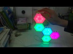 a person is working on some kind of colorful light up object that looks like hexagonal cubes