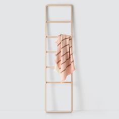 a piece of clothing hanging on a clothes rack in front of a white wall,