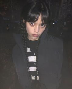 a girl with braids on her hair is looking at the camera while wearing a black jacket