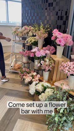 a woman standing next to a display of flowers in vases with the words, come set up a flower bar with me