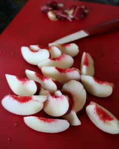 sliced up apples on a red cutting board