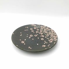 a black plate with pink flowers on it