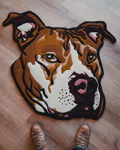 a brown and white dog is on the floor next to someone's feet