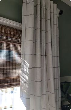 the curtains are hanging in front of the window with blinds pulled back to let light into the room