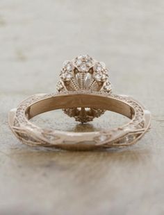 an antique style diamond ring sits on a table