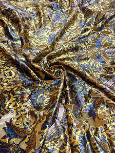 a close up view of a yellow and blue paisley print fabric