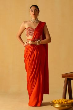 Burnt orange pre-draped saree in bamberg satin base. Paired with a dabka and zardosi embroidered blouse and belt. - Aza Fashions Orange Pre-draped Saree With Unstitched Blouse For Party, Orange Pre-draped Saree For Diwali, Bollywood Style Orange Pre-draped Saree For Party, Party Wear Orange Georgette Pre-draped Saree, Orange Georgette Pre-draped Saree For Party, Fitted Orange Pre-draped Saree, Orange Georgette Pre-draped Saree, Orange Traditional Drape Saree For Party, Orange Party Blouse With Traditional Drape