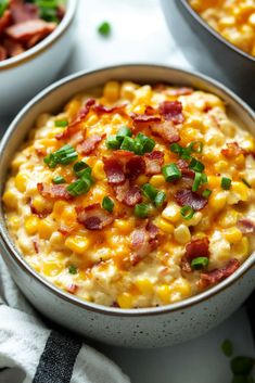 two bowls filled with macaroni and cheese topped with green onions