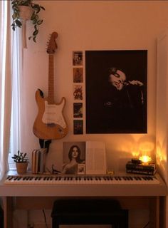 a room with a piano, guitar and various pictures on the wall next to it