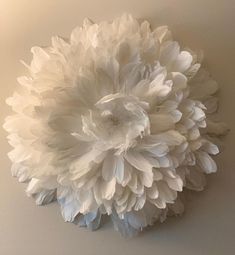 a large white flower is hanging on the wall