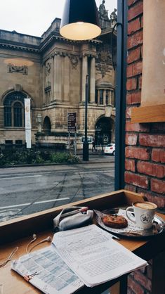 an open book sitting on top of a table next to a window