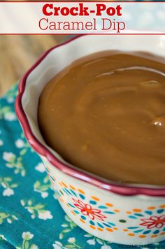 a bowl filled with caramel dip sitting on top of a blue and white cloth