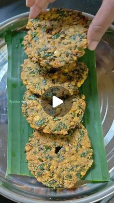 someone is placing food on top of a banana leaf