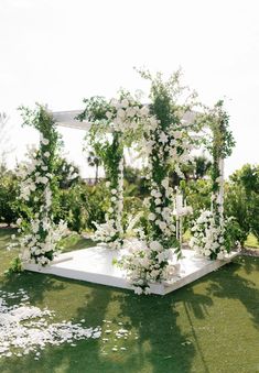 an outdoor wedding setup with white flowers and greenery