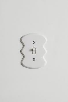 a white light switch on a white wall