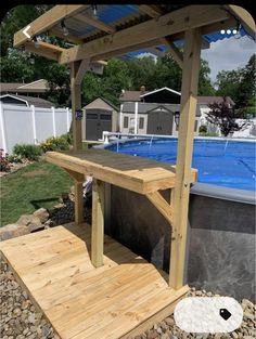 a wooden deck next to an above ground swimming pool with a blue cover over it