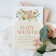 a baby shower card with flowers and greenery