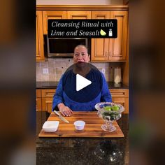 a woman sitting at a kitchen counter in front of a cutting board with food on it