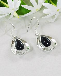 Immerse yourself in the graceful swaying hues of these beautiful statement earrings. Our authentic Black Onyx Earrings- Aura Drops are the epitome of elegance. Pretty teardrop gemstones are lovingly embraced within a sterling silver frame for a subtle, wholesome look. These earrings will add a playful refinement to any outfit, whether it's your blouse and work pants or leather jacket and jeans ensembles. Authentic Sivalya Black Onyx Black Onyx: Endurance, Perseverance, Grounding Hallmarked Metal Black Teardrop Gemstone Earrings, Black Teardrop Sterling Silver Earrings, Silver Onyx Teardrop Earrings, Black Sterling Silver Teardrop Earrings, Black Sterling Silver Teardrop Dangle Earrings, Elegant Black Teardrop Earrings In Sterling Silver, Elegant Black Teardrop Sterling Silver Earrings, Elegant Black Sterling Silver Teardrop Earrings, Black Onyx Earrings