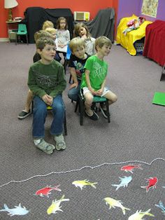 group of children sitting on chairs in room