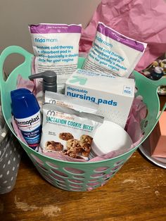 a basket filled with lots of items on top of a wooden table next to a pink bag