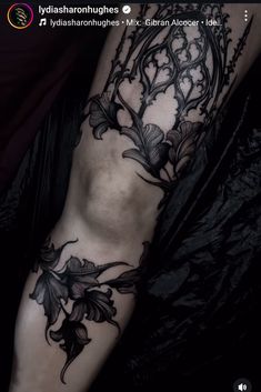 a woman's leg with flowers and vines on it