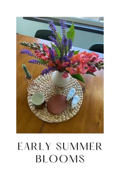 an image of a table setting with flowers on it and the words early summer blooms