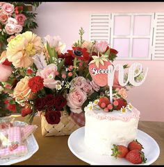 a table topped with two cakes covered in frosting next to baskets filled with flowers