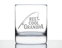 a glass with the words reel cool grandpa on it and a fishing rod in grey ink