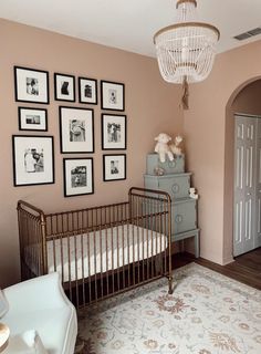 a baby's room with pictures on the wall and a crib next to it