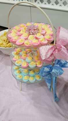 a basket filled with lots of cupcakes and cookies on top of a table