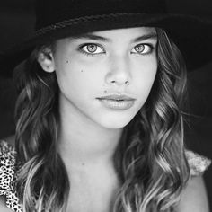 a woman with long hair wearing a hat