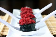 three sushi dishes with red cauliflower on them