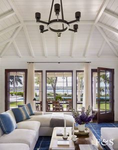 a living room filled with furniture and windows next to a blue rug on the floor