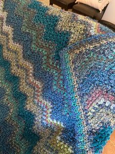 a crocheted blanket sitting on top of a bed