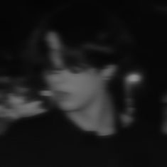 a blurry photo of a person in the dark with a cell phone up to their ear