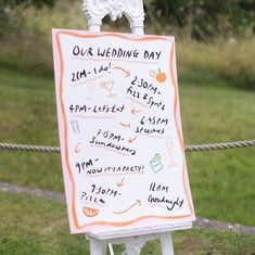 a white sign with writing on it sitting in the grass