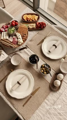 the table is set with plates, silverware and other food items on top of it