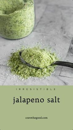 a scoop of jalapeno salt sitting on top of a table next to a jar