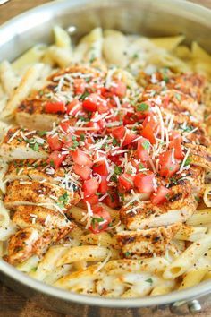 a pan filled with chicken, pasta and tomatoes