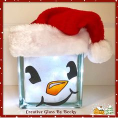 a glass block with a penguin face wearing a santa hat